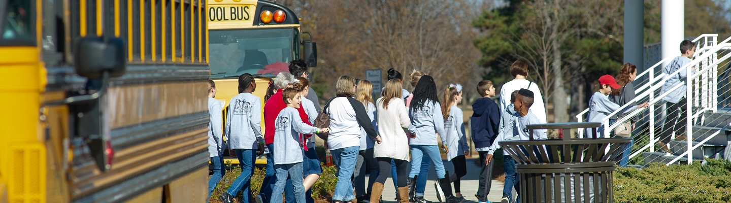 a group of people walking from school buses