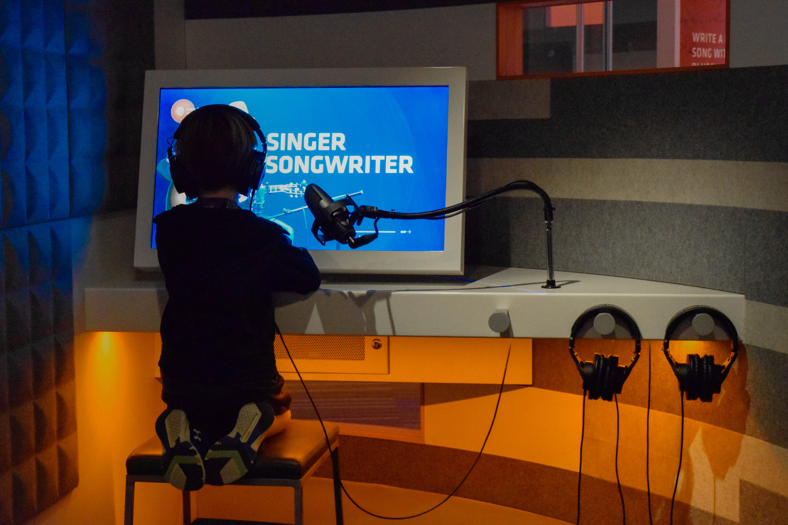 Child interacting with Singing & Songwriting / Producing Pods exhibit