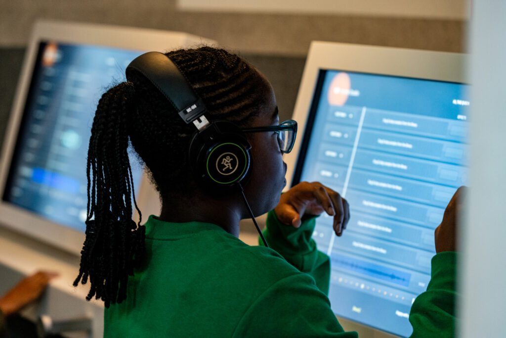 Girl with headphones using a computer.