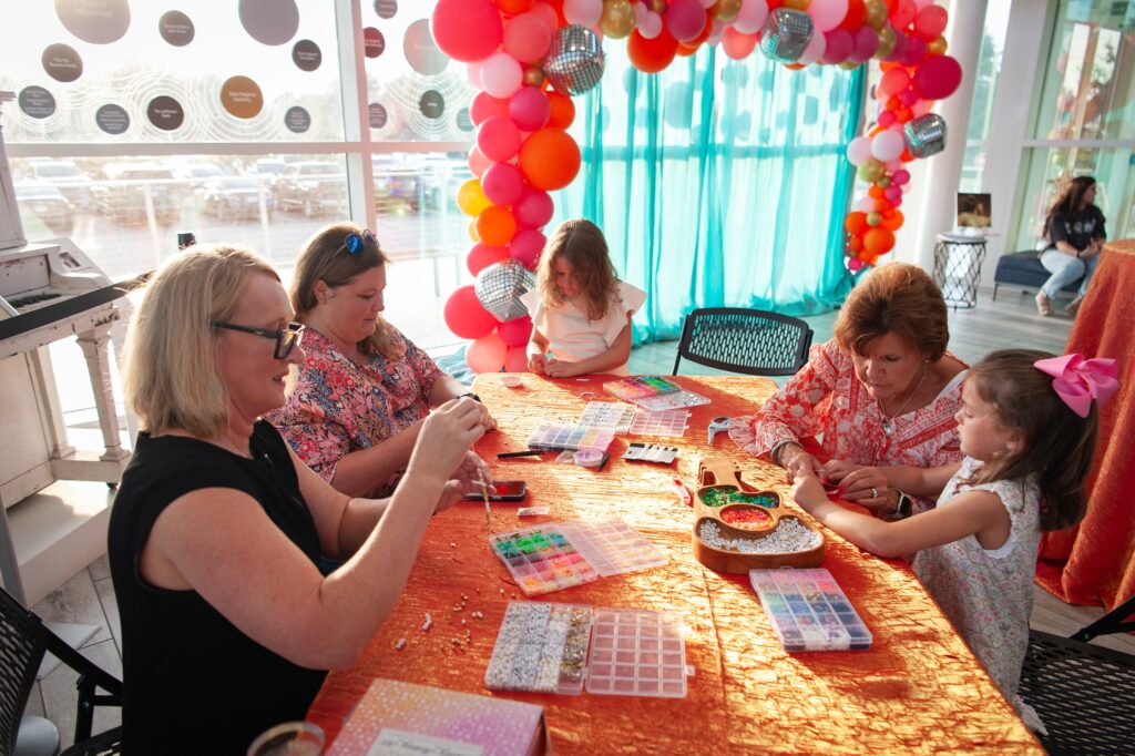 a group of women sitting at a table with balloons