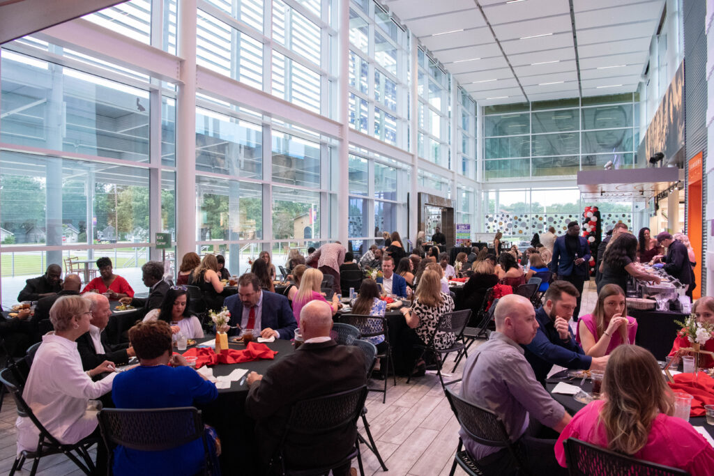 a group of people sitting at tables in a large room