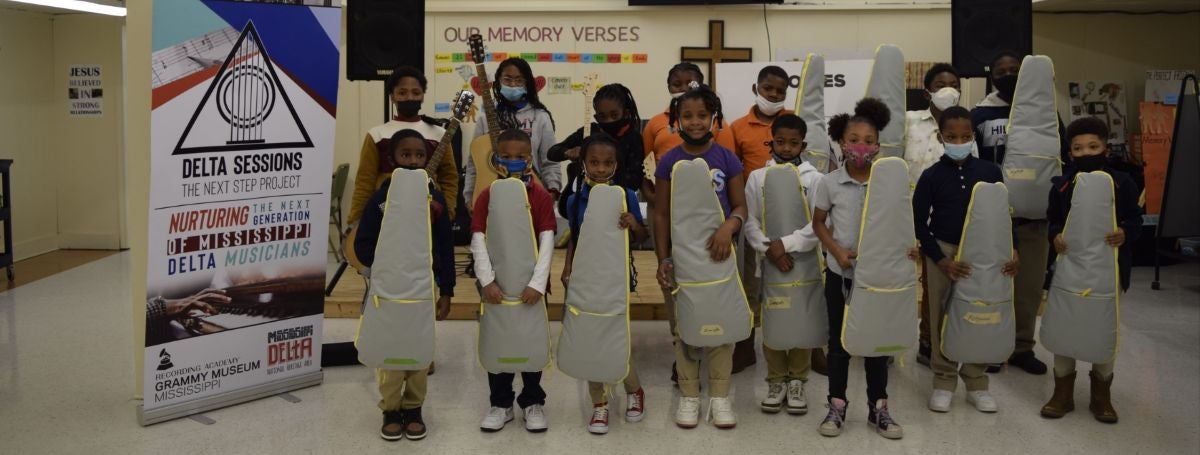 a group of children wearing masks and holding guitars