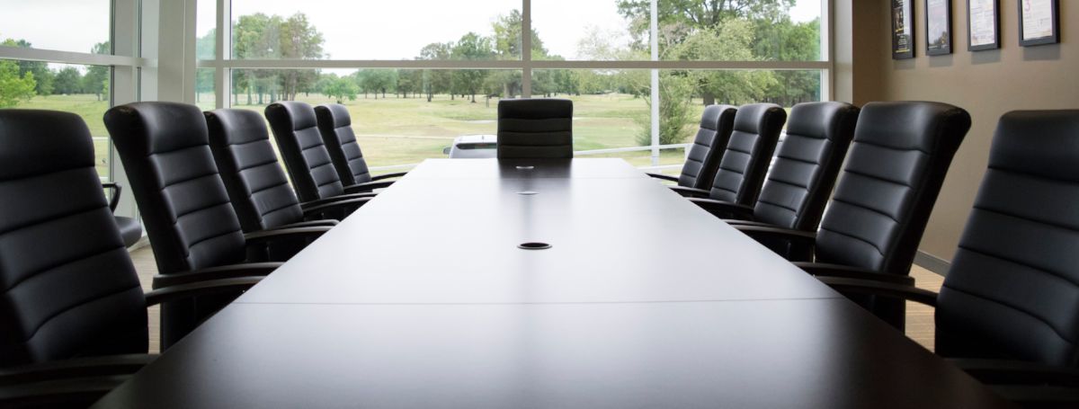 a conference table with chairs in front of a window