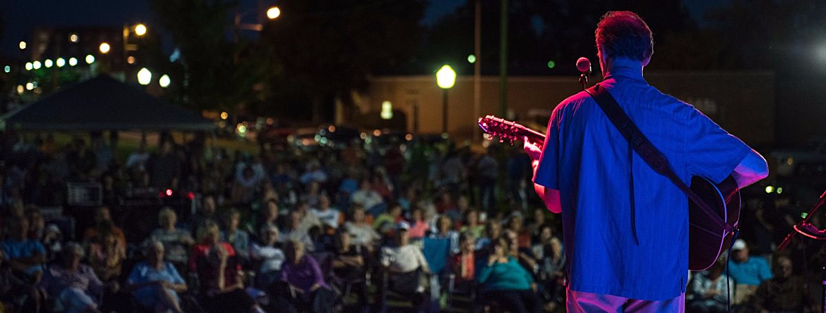 a man playing a guitar in front of a crowd